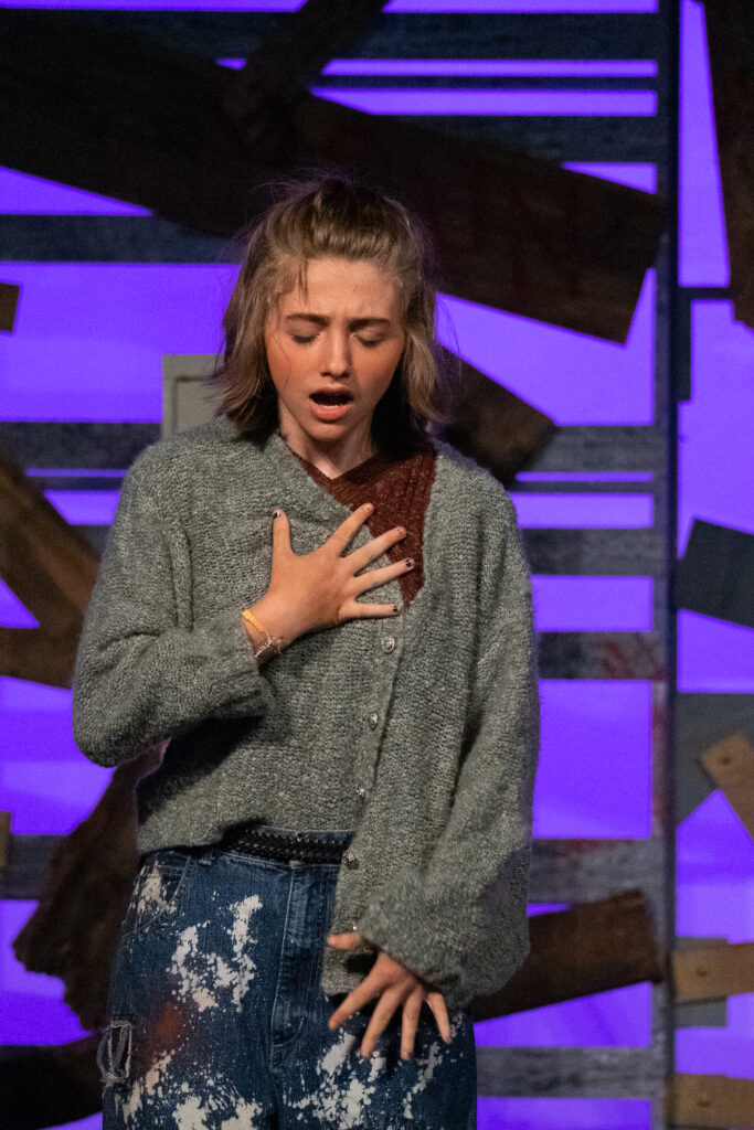 Kids performing a dramatic scene onstage during a theater camp production.