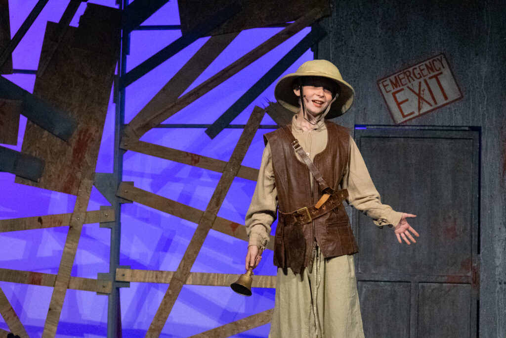 Kids performing a dramatic scene onstage during a theater camp production.