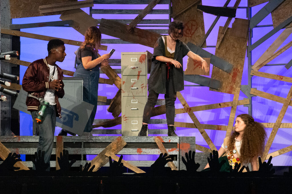 Kids performing a dramatic scene onstage during a theater camp production.