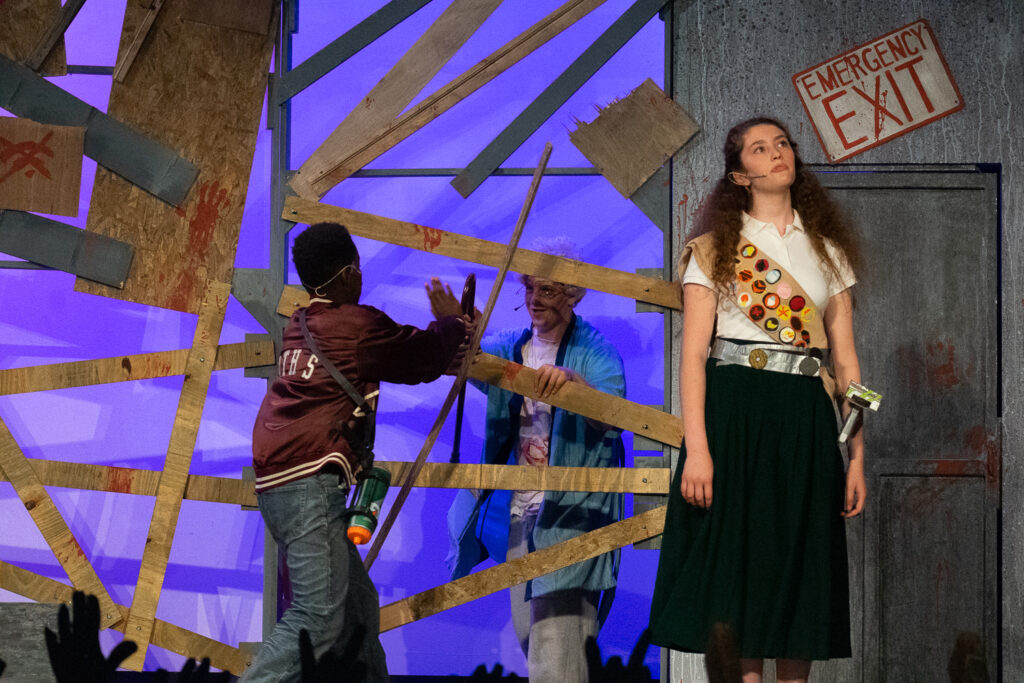 Kids performing a dramatic scene onstage during a theater camp production.
