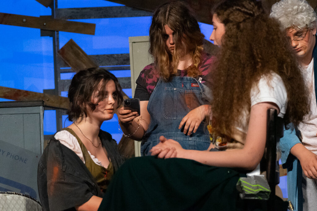 Kids performing a dramatic scene onstage during a theater camp production.