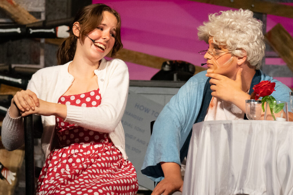 Youth actors performing a dramatic scene onstage at a summer theater camp.