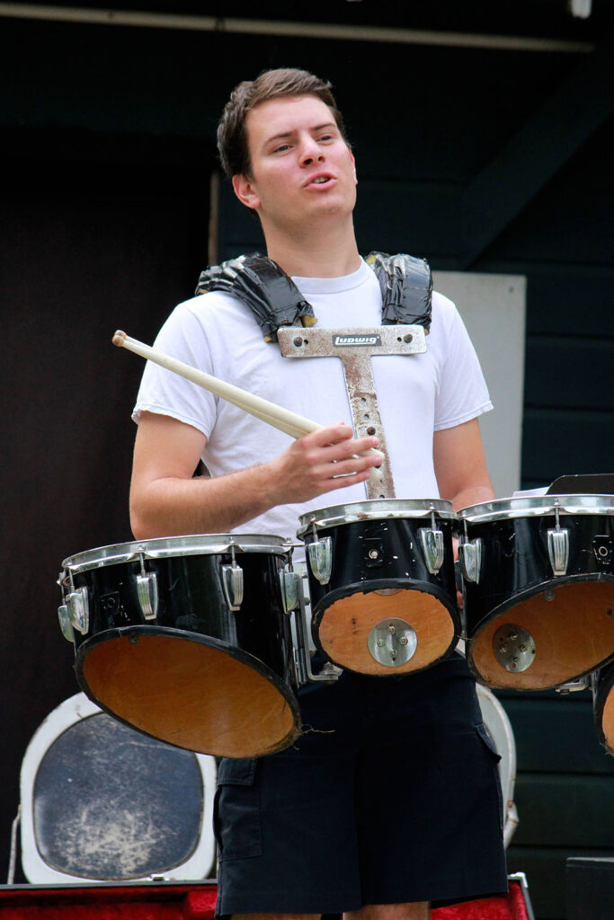 Drummer practicing with harness during music extravaganza rehearsal