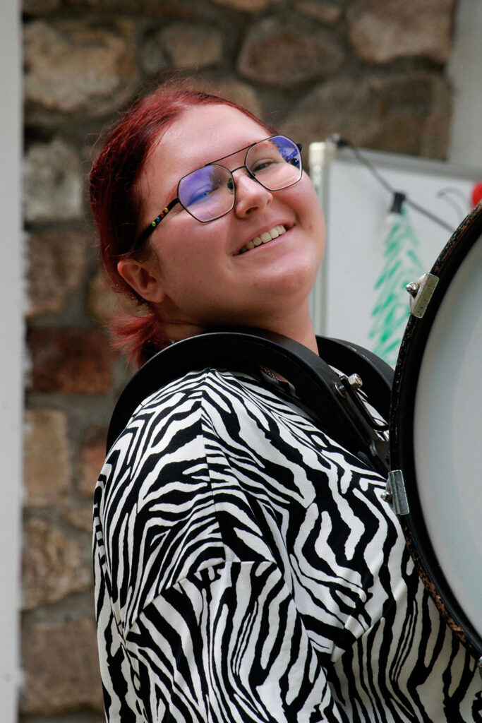 Camper smiling during drum rehearsal at summer performing arts camp