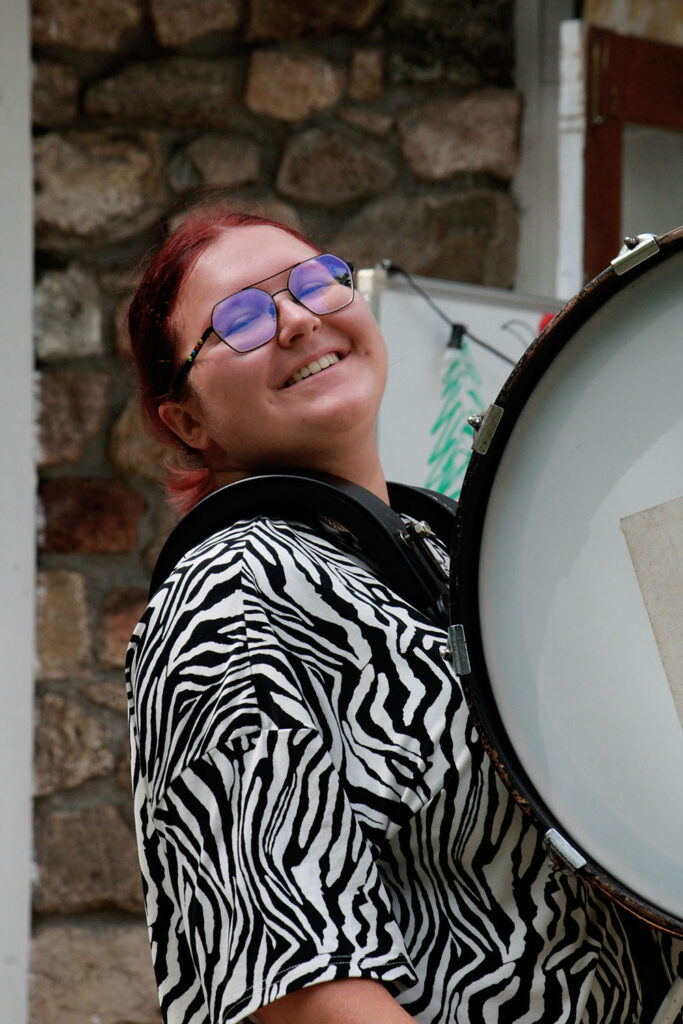 Percussion student wearing drum harness during music rehearsal