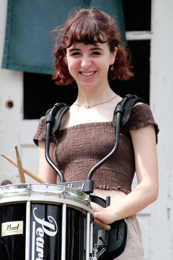 Young drummer practicing rhythm outdoors at Long Lake Camp
