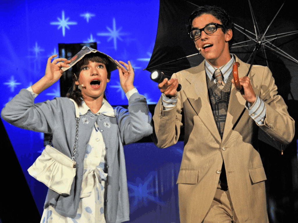 boy-girl-stage-costume – Long Lake Camp For The Arts Boy and girl in theatrical costumes acting on stage during a camp performance.