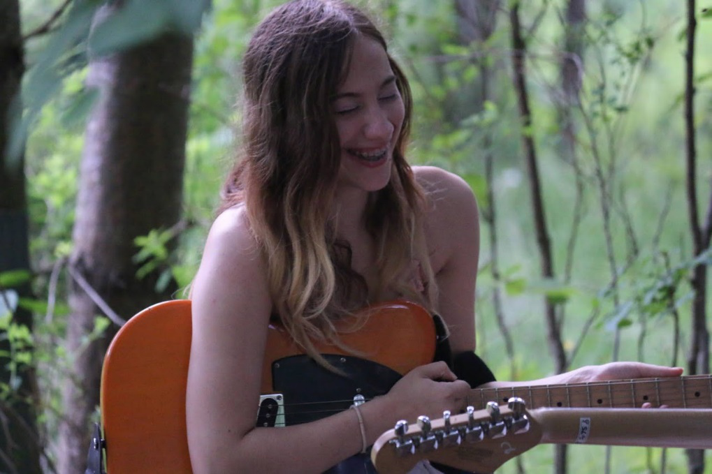 teen-girl-rehearsing-guitar-long-lake – Long Lake Camp For The Arts A teen girl rehearsing happily with her guitar at Long Lake Camp during music camp