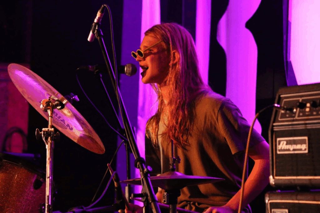 camper-playing-drums-rock-night-summer-music-camp – Long Lake Camp For The Arts A teen camper playing the drums confidently during Rock Night at music summer camp