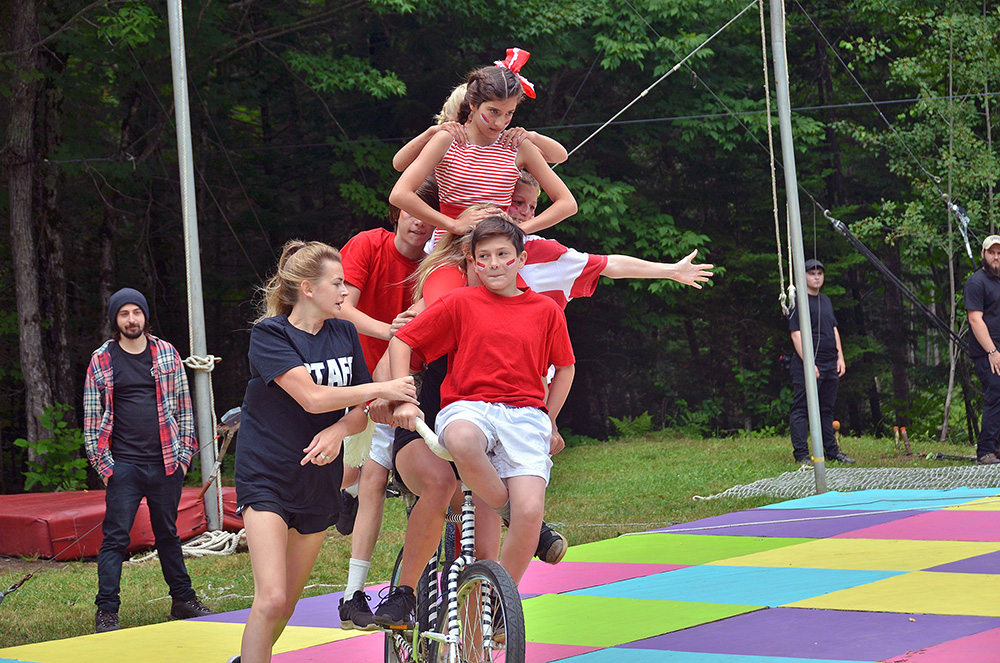 kids-bicycle – Long Lake Camp For The Arts A group of teenagers performing on a bicycle