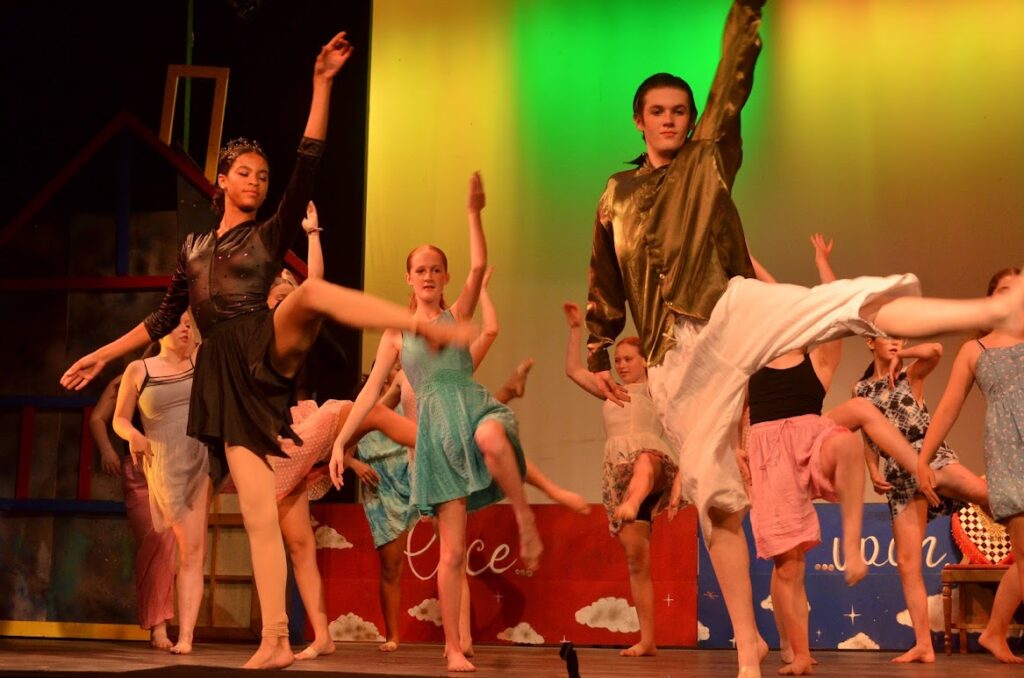 DSC_8001 – Long Lake Camp For The Arts Group of campers performing a synchronized dance routine on stage.