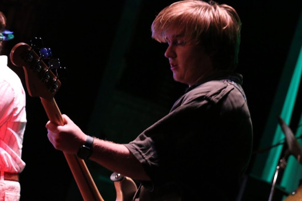 IMG_3694 – Long Lake Camp For The Arts Teen camper playing guitar on stage during a rock night performance