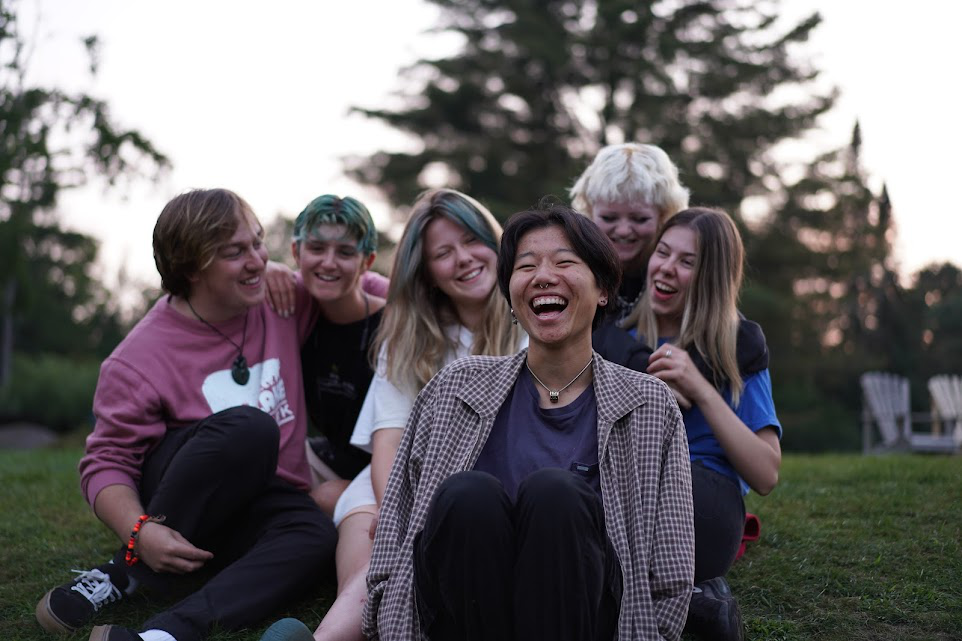 Picture22 – Long Lake Camp For The Arts Group of teen campers laughing together during an evening social event at camp
