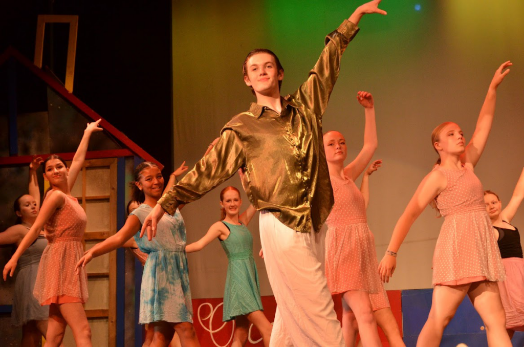 Picture24 – Long Lake Camp For The Arts Campers in costumes performing a synchronized sequence on stage at summer camp.