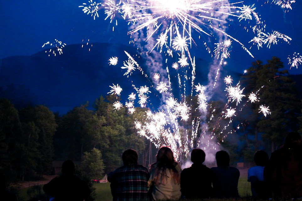 Picture8 – Long Lake Camp For The Arts Teen campers sitting together watching a fireworks show at camp.