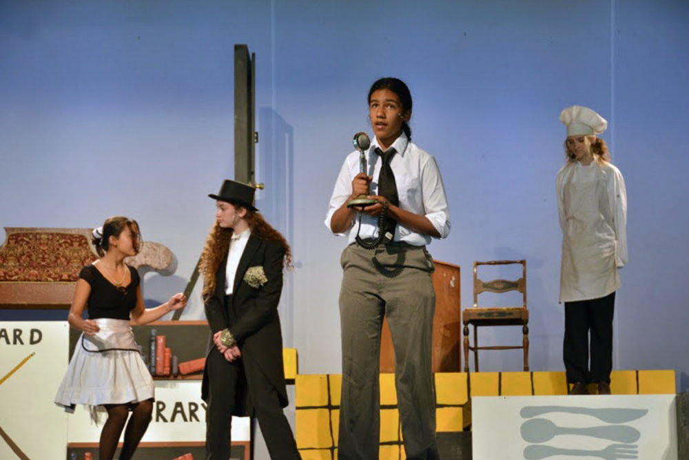 Young campers performing together in costumes on stage